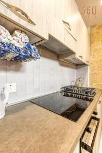 uma cozinha com um balcão e um fogão forno superior em Authentic 2BR House of Character with Terrace by 360 Estates em Naxxar