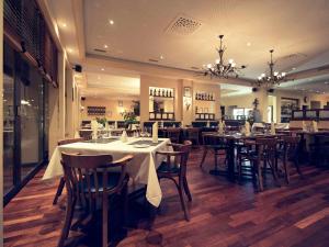 a dining room with tables and chairs in a restaurant at Mercure Biel in Biel