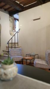 ein Zimmer mit Stühlen, einem Tisch und einer Treppe in der Unterkunft Etrusco Home & Relax in Pitigliano