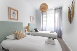 2 camas en una habitación blanca con ventana en Xirimiri apartment by People Rentals en Bilbao