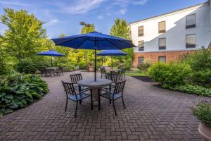 eine Terrasse mit Tischen, Stühlen und Sonnenschirmen in der Unterkunft Hampton Inn Harriman Woodbury in Central Valley