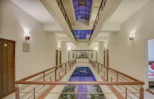 a hallway with a pool of water with a stained glass ceiling at Super Hotel O Plus Corporate One in Nagpur