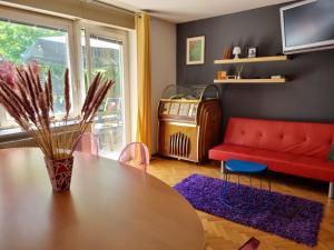 a living room with a table and a red couch at Sax Pub Hostel Ljubljana in Ljubljana