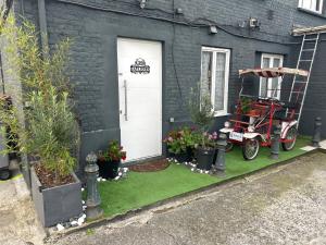 a house with a yard with plants and a motorcycle outside at Haylenes in Tourcoing