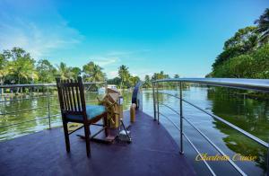 ein Boot auf einem Fluss mit einem Stuhl auf dem Deck in der Unterkunft Charlotte Cruise House Boat in Alappuzha