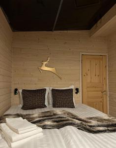 a bedroom with a large bed with a wooden wall at Skyfire Village Igloos in Rovaniemi