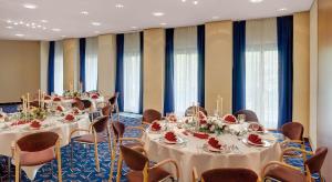 una sala de conferencias con mesas, sillas y ventanas en Congress Hotel Chemnitz en Chemnitz