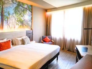 a hotel room with a large bed and a window at Novotel Itu Terras de São José Golf & Resort in Itu