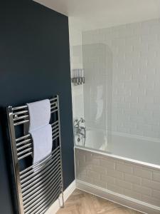 uma casa de banho com uma banheira e um toalheiro. em Divers Cottage - Central Whitstable em Whitstable mais 20 fotografias