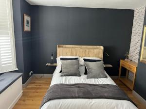 a bedroom with a large bed with blue walls at Divers Cottage - Central Whitstable in Whitstable