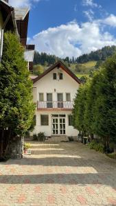 a large white house with trees in front of it at La Perla in Moieciu de Sus