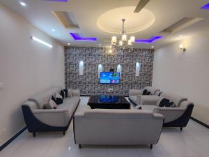 salon z kanapami i telewizorem z płaskim ekranem w obiekcie Luxury Holiday Home in Islamabad w mieście Islamabad