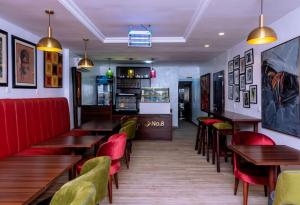 a restaurant with wooden tables and red chairs at No.8 Boutique Hotel in Ilorin