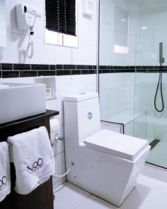 a white bathroom with a toilet and a shower at No.8 Boutique Hotel in Ilorin