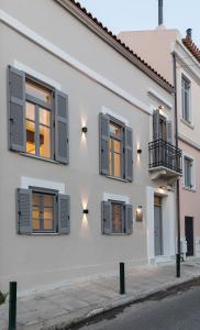 uma casa branca com janelas e uma varanda em New Villa In Downtown em Atenas