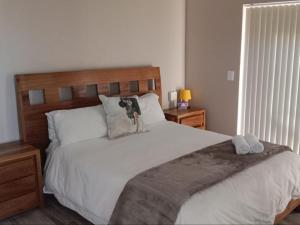 a bedroom with a large bed with two towels on it at Hopslot Villa in Mossel Bay