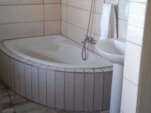 a bath tub and a sink in a bathroom at Hopslot Villa in Mossel Bay +47 photos