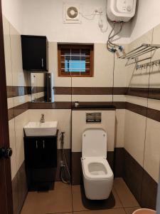 a small bathroom with a toilet and a sink at Agasthya Private Pool & Park villa in Sultan Bathery