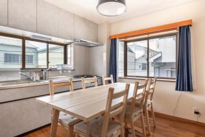 cocina y comedor con mesa de madera y sillas en 平井戸建 en Tokio
