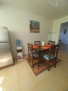 a dining room with a table and chairs and a refrigerator at Emily Apartments Kisumu on Hatupe Enterprises Ltd Building in Kibos