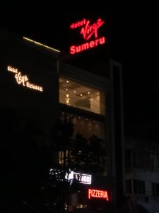 a building with neon signs on the side of it at Hotel Virgo Sumeru in Bhavnagar