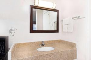 a bathroom with a sink and a mirror at Travelodge by Wyndham Las Vegas NM in Las Vegas