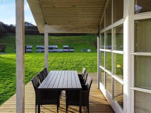 a porch with a wooden table and chairs on it at 8 person holiday home in Lemvig in Lemvig