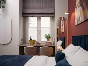 1 dormitorio con cama, mesa y ventana en Hidden Garden Apartments, en Łódź