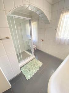 Un baño con ducha, lavabo e inodoro. en The Valley Guest House, en Pietermaritzburg