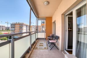 uma varanda com uma mesa e cadeiras. em Gold apartman em Podgorica