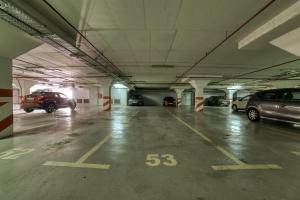 uma garagem de estacionamento com vários carros estacionados nela em Gold apartman em Podgorica