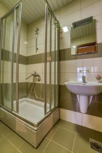 uma casa de banho com um chuveiro e um lavatório. em Gold apartman em Podgorica