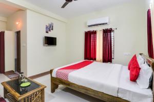 a bedroom with a large bed and a table at OYO Flagship Hotel Vaiko in Khandagiri