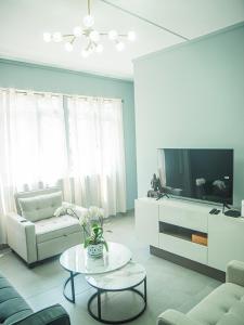 a living room with a couch and a tv at Gorgeous KEJ in Pereybere 2 Bed Apartment in Pereybere