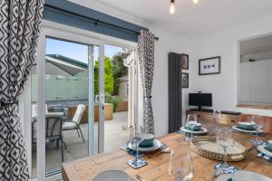 une salle à manger avec une table en bois et des portes vitrées dans l'établissement Harleys Way - Short Walk to Beach and Village, à Saundersfoot