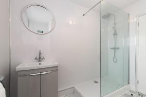 une salle de bain blanche avec un lavabo et un miroir dans l'établissement Harleys Way - Short Walk to Beach and Village, à Saundersfoot 39 autres photos