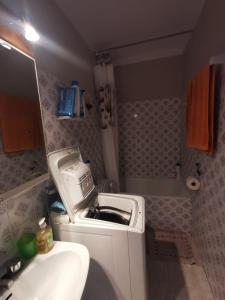 uma pequena casa de banho com um lavatório e uma máquina de lavar roupa em Appartement avec Piscine et Vue Canaux em Roses