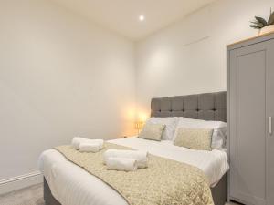 una camera da letto con un grande letto con due cuscini sopra di Pass the Keys Modern Apartment With Courtyard a Madeley