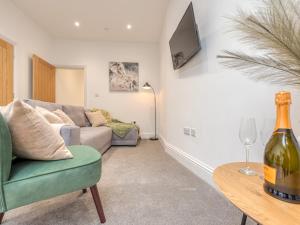 a living room with a couch and a table with a wine glass at Pass the Keys Modern Apartment With Courtyard in Madeley