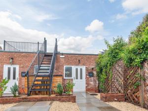 a brick house with a spiral staircase on it at Pass the Keys Modern Apartment With Courtyard in Madeley