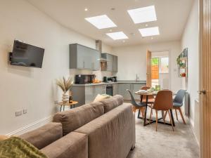 a living room with a couch and a kitchen at Pass the Keys Modern Apartment With Courtyard in Madeley