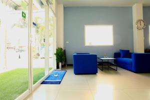 a living room with a blue couch and a table at Kata Sea Host in Kata Beach