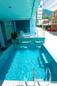 a swimming pool in a building with a sign in it at Kata Sea Host in Kata Beach