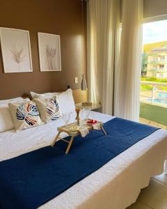 a bedroom with a large bed with a table on it at Flat E311 - Aldeia das águas in Barra do Piraí