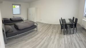 a room with a table and a bed and a dining room at AlWi Appartements Moringen in Moringen
