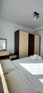 1 dormitorio con 1 cama blanca grande y espejo en Elite Apartment in Bishkek Park Residence, en Bishkek
