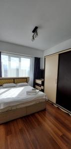 1 dormitorio con cama grande y ventana grande en Elite Apartment in Bishkek Park Residence, en Bishkek