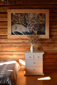 a bedroom with a painting on the wall and a dresser at Chata Mioduszyna w Beskidach - drewniany dom z widokiem na Babią Górę in Maków Podhalański