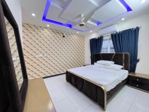 1 dormitorio con 1 cama y techo azul en Luxury Holiday Home in Islamabad en Islamabad