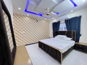 a bedroom with a bed and a blue ceiling at Luxury Holiday Home in Islamabad in Islamabad